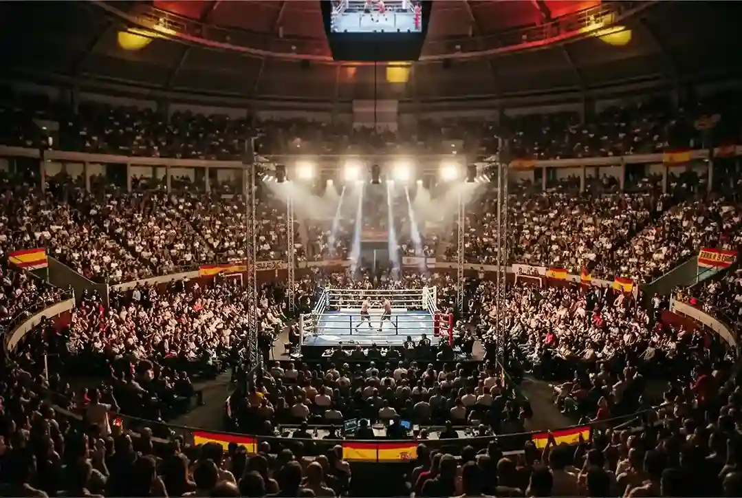 Panorámica de un estadio de boxeo con el público durante una velada en España